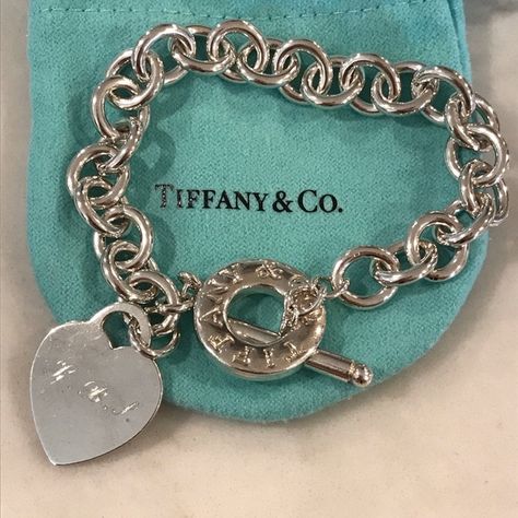 Tiffany & CO Toggle Bracelet Just polished and cleaned. Heart tag has my initials ‘KBS’ lightly engraved, but Tiffany’s has informed me they can be buffed out like new for $50 and engraved again for additional. Or can remove heart, as the toggle closure says Tiffany & CO on it!  Inspired by the iconic key ring first introduced in 1969, the Return to Tiffany collection is a classic reinvented. A timeless bracelet.  Sterling silver toggle bracelet, 8" long. Comes with pouch. Tiffany & Co. Jewelry Tifanny Co Bracelet, Tifanny And Co Bracelet, Timeless Bracelet, Vision 2024, Tiffany And Co Jewelry, Tiffany Bracelets, Return To Tiffany, Heart Tag, Toggle Bracelet