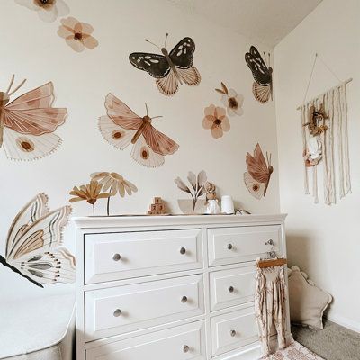 Whimsical and warm, the Butterfly Wall Decals from Urbanwalls deliver natural charm to any space. Created from toasted neutral tones, the decal pack features a variety of flowers and foliage with three variations of delicate butterflies. Gracie Oaks | Gracie Oaks Wall Decal black / whiteVinyl in Pink | 50" H X 50" W | Wayfair | Home Decor Lily Pad Nursery Theme, Gold And Pink Nursery Decor, Vintage Gothic Nursery, Butterfly Nursery Theme Boho, Boho Butterfly Bedroom, Floral Theme Nursery, Toddler Butterfly Room, Butterfly Garden Nursery, Butterfly Toddler Room