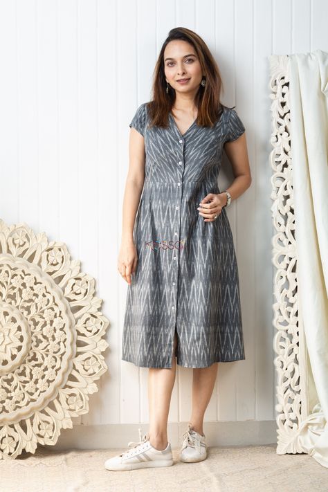 Cut in a distinct mid length A-line silhouette, the ikat grey mid-length dress is carefully handwoven with a dainty ikat pattern in grey and white tones. A great choice for daily-wear, this soft cotton outfit is embellished with front buttons, side pleats and V-neck. The dress comes with two side pockets. Daily Wear Kurtas Cotton, Ikat One Piece Dress, Front Button Frock Design, Cotton Daily Wear Dresses, Cotton A Line Frocks For Women, Simple Daily Wear Kurti Design, Cotton Ikat Dress, Aline Cotton Dress, Cotton Frock Ideas For Women