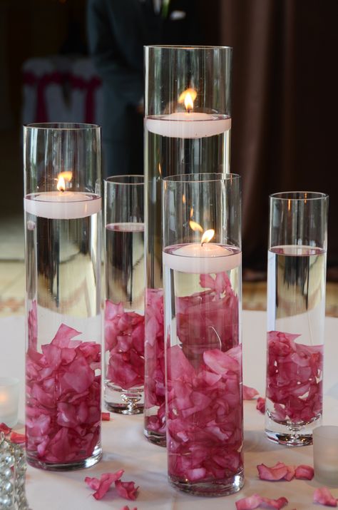 water, glass, flowers add reflections to the candle lights Floating Petals Centerpiece, Wedding Decor Floating Candles, Simple Candle Table Decor, Tall Vase Centerpiece Ideas, Glass Cylinder Ideas, Floating Candles Centerpieces, Cheap Table Decorations, Candles Inspiration, Floating Petals