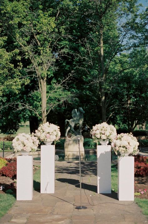 Romantic pink and white floral arrangements on pillars for an outdoor garden ceremony Ceremony Columns With Flowers, Wedding Aisle Pillars, Columns With Flowers Wedding, Pillars For Wedding Ceremony, Wedding Pillars Ceremony, Floral Pillars Wedding, Pink And White Floral Arrangements, Ciara Wedding, White Wedding Flower Arrangements