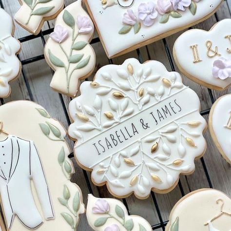 Cococasa Kitchen on Instagram: "I think I made one of my favorite designs ever! The cookie with the gold and white leaf highlights has my heart ✨ This one’s for an NYC wedding! Did you notice the pastel cabs? . . . ——————————- Link in bio for enquiries! ——————————- #newyorkcity #baker #newyorkbaker #chefsofinstagram #homebaker #royalicingcookies #newyorkcitycakes #cococasa #cococasakitchen #womenownedbusiness #customcookies #customcookiesnyc #customcookiesnewyork #uppereastside #supportsmall Modern Wedding Cookies, White And Gold Engagement Cookies, Cookies With Names On Them, Wedding Cake Cookies Decorated, White And Gold Cookies, White Wedding Cookies, Heart Wedding Cookies, Wildflower Cookies, Cookies Drawing