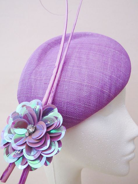 Lilac sculpted pillbox hat with simple yet elegant curved quils, finished off with a statement sequin flower making it a very fun piece to wear to the races! Attaches to the head via elastic.    |  Hat Shape: Pillbox |  Colour: Purple |  Features/Construction: Feathers, Flowers, Sinamay, Spring/Summer |  Condition: New |  Price: 180 GBP  |  Milliner: SB Millinery  |  Item Location: United Kingdom Donut Hat, Sequin Flower, Different Hats, Yellow Hat, Feather Flower, Boater Hat, Designer Hats, Pillbox Hat, Colour Purple