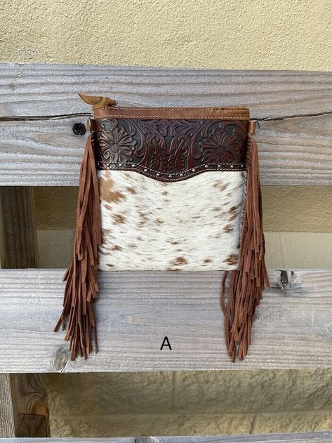 Top Notch Accessories Cowhide Crossbody Fringe Purse ﻿Meet Betty she is the perfect size for the girl on the go. This bag measures at 8 1/4" high and 7 1/4" wide, it is approximately 1" deep. It has a removable, adjustable strap that is 51" long. This fringed bag features a zippered closure, back pocket, and brown top with embossed leather. Fringe Crossbody Bag, Fringe Purse, Brown Top, Cow Hide, Leather Fringe, Leather Craft, Embossed Leather, Leather Purses, Wallets