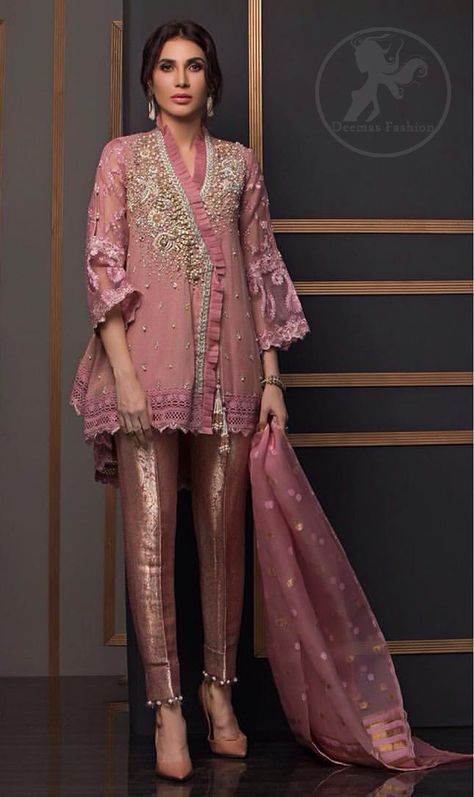 This outstanding angrakha style shirt meticulously highlighted with dull golden and antique shaded kora, dabka , tilla, sequins and pearls. This dress is beautifully adorned with floral embroidery. Sleeves are decorated with resham embroidery which adds to the look. It comes with brocade straight pants. It is beautifully coordinated with chiffon dupatta having sprinkled sequins all over it. Top: Angrakha Shirt Angrakha Style Short Frock, Angrakha Style Shirt, Short Frocks, Resham Embroidery, Angrakha Style, Short Frock, Pakistani Bridal Dresses, Pakistani Bridal Wear, Stylish Party Dresses