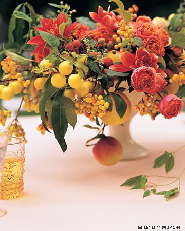 Fruit is left on the vine or branch to create alluring arches in this centerpiece Fruit Centerpieces Wedding, Red Wedding Centerpieces, Fruit Centerpieces, Flowers And Fruit, Fruit Wedding, Orange Wedding Flowers, Festa Harry Potter, Fall Flower Arrangements, Fall Floral Arrangements