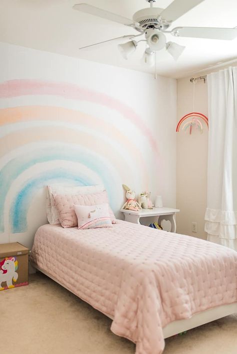 Beautiful bedroom for a little girl! Lots of pink, rainbows, and unicorns to turn her bedroom into a princess dream. With the rainbow mural accent wall (simple wallpaper rainbow!) and the feminine pink bedding from Pottery Barn Kids, this little girls bedroom will be her favorite place to sleep. Girls Rainbow Bedroom, Girls Dream Bedroom, Girls Bedroom Themes, Rainbow Mural, Rainbow Bedroom, Girls Bedroom Makeover, Unicorn Bedroom, Pink Bedroom For Girls, Toddler Bedroom Girl