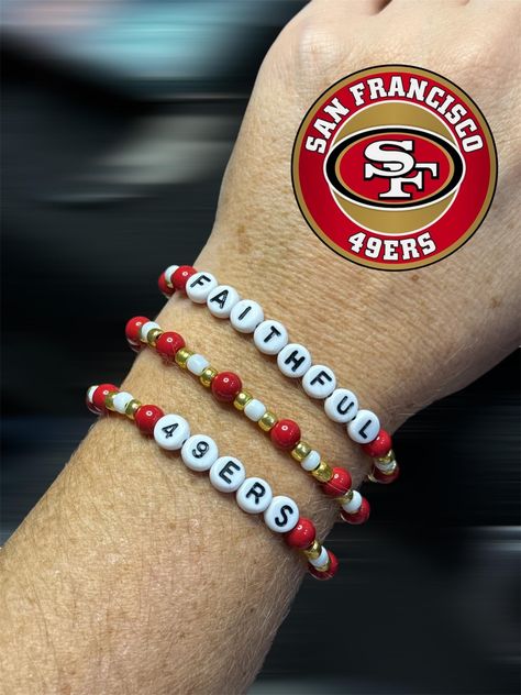 New Handmade San Francisco 49ers Bracelet Set (3 pieces) Show your Faithful spirit with these handmade San Francisco 49ers bracelets! Perfect for game day or everyday wear. Each bracelet features: Red, gold, and white beads in team colors Stretch cord for comfortable fit. Bracelet details: Approximately 7" unstretched, fits most wrists Handcrafted with care using quality materials Great gift for any 49ers fan!  Wear your Niners pride on your wrist with these eye-catching, spirited bracelets. Go 49ers Bracelet Ideas, San Francisco 49ers Football, 49ers Fans, 49ers Football, Bangle Bracelets With Charms, Stackable Bracelets, Bracelets Handmade Beaded, San Francisco 49ers, White Beads