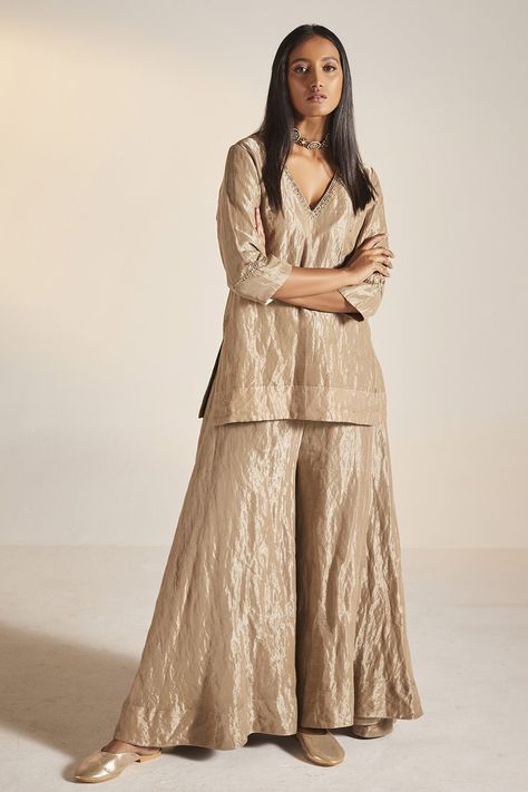 Champagne grey kurta in handloom tissue fabric base and embroidered neckline. Paired with tiered sharara. Component: 2 Pattern: Embroidery Neckline: V neck Sleeve Type: Three quarter Fabric: Handloom Tissue Color: Grey Other Details:  Approximate Product Weight (in kg): 1 Embroidered neckline Tiered sharara Note: Dupatta worn by the model is not for sale Outfit worn by the model on right is not for sale Since all our products are sustainable and touched by human hands for weaving, block printing Kurta And Sharara Set, Kurta And Sharara, Gold Suit, Trendy Outfits Indian, Pakistani Fancy Dresses, Traditional Indian Outfits, Kurti Designs Party Wear, Designer Dresses Casual, Designer Party Wear Dresses