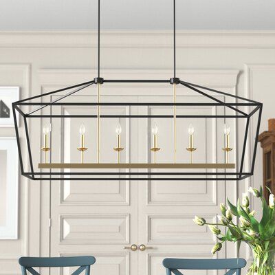 This 6-light linear pendant creates a bright focal point in your kitchen or dining room. It’s made from steel, with a lightly distressed, hand-painted black and gold finish. This pendant has an airy, geometric lantern silhouette that adds a modern touch. It hangs from two parallel downrods and a sloped ceiling-compatible canopy. Its six candle-style fixtures hold six 60W bulbs (sold separately). We love that this pendant is compatible with a dimmer switch, to let you choose the ambiance in your Black Pendant Light Dining Table, Black And Gold Chandelier Dining Room, Linear Chandelier Over Island, Rectangle Chandelier Dining Room, Linear Chandelier Dining Room, Linear Kitchen Island Lighting, Lantern Silhouette, Real Candles, Geometric Lantern