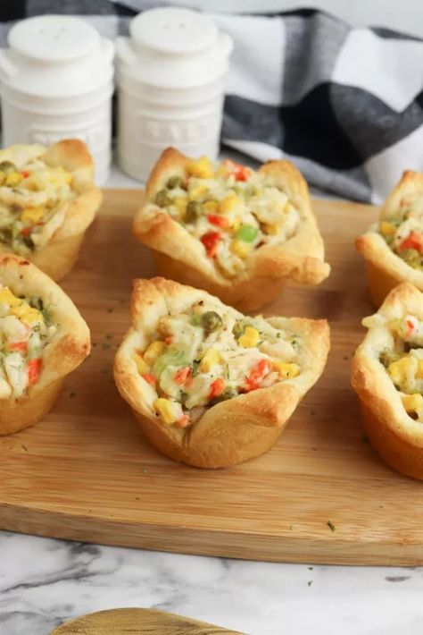 are fun and easy to make for any holiday party. These mini crescent dough cups are filled with chicken pot pie filling and baked. They are the perfect bite-sized appetizer to hand out at Thanksgiving. Your family and friends will love them!     Chicken Pot Pie Crescent Rolls  These individual chicken pot pies are made by placing the crescent dough in the cups of a muffin tin to use as the crust and then filling them up with the pot pie mixture and baking in the oven. Instead of making an… Pot Pie Crescent Rolls, Chicken Pot Pie Crescent Rolls, Pot Pie With Crescent Rolls, Individual Chicken Pot Pies, Chicken Pot Pie Filling, Low Fat Chicken, Baked Pork Chops Oven, Chicken Pot Pie Recipe, Pot Pie Filling