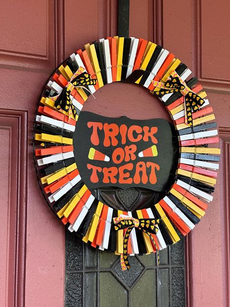 Handcrafted Halloween clothespin wreath. All clothespins were painted and attached to a wire form wreath. Wooden sign added to the middle, supported to the back. 3-2 ribbon added. I must say that I'm in love with how this turned out. If I don't sell it, I'm keeping it! 😂 This will look great along with your additional Halloween decor! Mini Clothespin Crafts Diy, Diy Clothespin Crafts, Christmas Clothespin Wreath, Halloween Wreath Ideas Diy Dollar Tree, Clothes Pins Ideas, Clothes Pins Crafts, Halloween Crafts Dollar Tree, Halloween Wreath Ideas Diy, Clothespin Wreath Diy