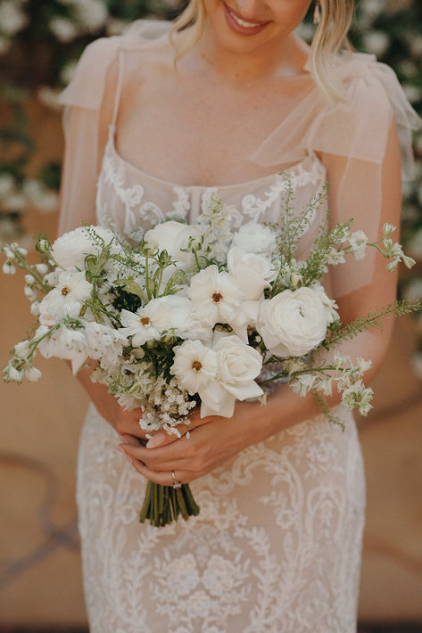 Elegant white modern bridal bouquet with roses, dahlias, and ranunculus, showcasing minimalist design and timeless beauty for a chic wedding day. Minimal Bridal Bouquet White, Simple Bridal Party Bouquets, Timeless Elegant Wedding Bouquet, Neutral Summer Wedding Flowers, White Poppies Bouquet, Simple Modern Bouquet, White Dahlia Wedding Bouquets, White Wild Flowers Wedding, White Boquetes Of Flowers Wedding