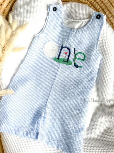 Step onto the green in style with our adorable golf-themed baby boy outfit, perfect for his first birthday celebration!  Crafted from soft gingham cotton, this short overall romper is as comfortable as it is charming.  The outfit features an embroidered golf-themed 'one' on the chest, adding a touch of sporty elegance to his special day.  Whether you're going for a 'hole in one' theme or a fun 'let's par-tee' celebration, this outfit is sure to make him the star of the day! Size chart: 9-12 mont Golf First Birthday Photoshoot, Par Three Golf Birthday, First Birthday Boy Golf, Golf Smash Cake Baby Boy, Hole In 1 First Birthday, 1st Bday Cake Smash, First Birthday Golf Theme, First Birthday Themes Boy, Hole In One First Birthday