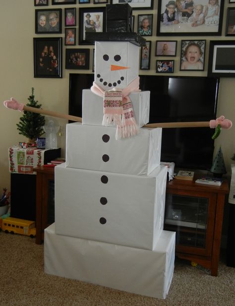 We had some oversized boxes to wrap this year, so this grandma used white wrapping paper and created a 6-foot snowman! The gifts that made the top hat were wrapped using a black trash bag. The arms were wrapping paper tubes. The buttons and face were just construction paper pieces glued on. Bonus for the kids - the bottom gift (a big tool box) was packed full of smaller wrapped presents! They loved finding those when they thought there were no more to open! Wrapping Big Boxes, Snowman Wrapped Presents, Snowman Presents Tower, Snowman Gift Tower Instructions, Snow Man Gift Boxes, Snowmen Present Boxes, Cute Gift Wrapping Ideas, Fun Holiday Crafts, Christmas Dreaming