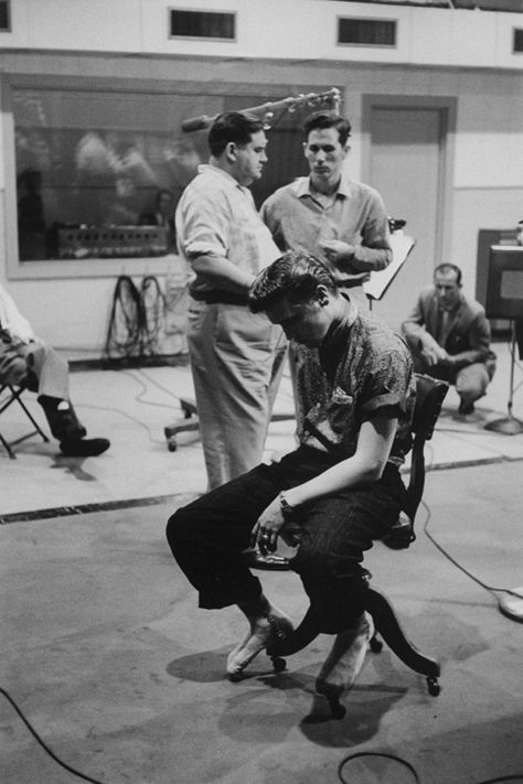 Singer Elvis Presley, in stocking feet and looking tired and somewhat dejected, sitting in chair during break from recording new record at the RCA studio in Nashville while head of Country and Western Artist and Repertoire, Steve Sholes, is talking to producer Chet Atkins in the background. Elvis Presley's Birthday, Music Row Nashville, Miss Tennessee, Scotty Moore, Chet Atkins, Elvis Presley Images, Music Row, Sun Records, Young Elvis