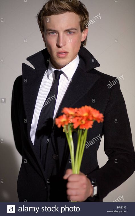 A male model holding flowers during a photo shoot at a studio in ... Guy Holding Flowers, Holding Flowers Pose Reference, Flower Shoot, Indoor Shoot, Culver City California, Male Pose Reference, Edit Ideas, Holding Flowers, Los Angeles Usa