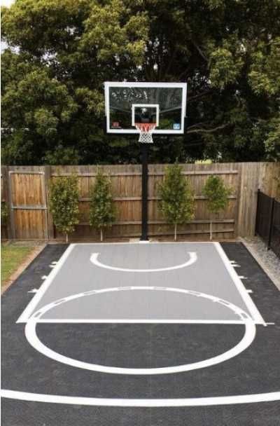 27 Outdoor Home Basketball Court Ideas | Sebring Design Build Basketball Pad In Backyard, Corner Basketball Court, Basketball Area In Backyard, Small Backyard Basketball Courts, Basketball Court Driveway, Mini Basketball Court Backyard, Basketball Driveway Ideas, Basketball Home Court, Small Home Basketball Court