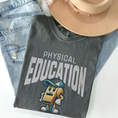 ### Product Description: "Physical Education" Retro Mascot T-Shirt #### Overview: Celebrate your passion for teaching physical education with our "Physical Education" Retro Mascot T-shirt! Featuring a charming retro mascot--a whistle wearing a ball cap--this shirt is designed especially for PE teachers who want to add a playful and nostalgic touch to their wardrobe. #### Ideal For: - **PE Teachers Show off your profession with pride and add a fun, retro vibe to your daily attire. - **School Staff A great way for school staff to promote physical education and team spirit. - **Gifting An excellent gift for PE teachers, coaches, or anyone passionate about fitness and education. #### Why You'll Love It: This T-shirt combines comfort, style, and a touch of nostalgia, making it a perfect additio Physical Education Teacher Gifts, Coach Sweatshirt, Retro Mascot, Coach Outfits, Pe Teacher, Coach Shirt, Education Shirts, Physical Education Teacher, Pe Teachers