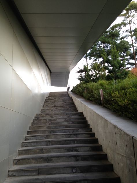 Rem Koolhaas was here. Seoul National University Museum Of Art was designed by OMA. The building's form was conceived as a basic rectangular box, sliced diagonally by the incline of the hill. This form is then raised up on a small central core – the only point of contact with the ground – so the building is nearly all cantilever, extending up and down the hill, following the topography precisely and appearing to hover above it.  Seoul/South Korea  photo credit: Selim Senin South Korea Photo, Seoul National University, Korea Photo, Rem Koolhaas, National University, Korea Travel, Seoul South Korea, Architectural Designs, The Hill