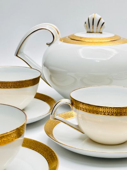 Elevate your tea time with this exquisite Narumi Tea Set from Japan. Crafted with precision and elegance, this set includes 1 teapot, 6 tea cups, and 6 saucers. Every piece in this luxurious collection is in remarkable vintage condition, a testament to Narumi's commitment to quality. You'll find no chips or cracks here, and the ornate patterned gold trim is as resplendent as the day it was crafted. White And Gold Tea Set, White Tea Set, Gold Tea, Japanese Porcelain, Creamy Texture, Tea Service, Classic Elegant, Tea Sets, White Tea