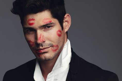 Stylish young guy covered with kiss marks on face. Good looking model standing against grey background. Guy With Kiss Marks, Face With Kiss Marks, Kiss Marks, Marks On Face, Red Lipstick Kisses, Model Standing, Kiss Mark, Lipstick Kiss, Grey Background