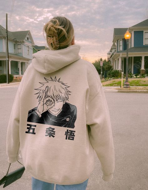 This vintage Gojo Satoru anime hoodie is the perfect anime lover and jujutsu kaisen hoodie. It can be a gift for him or a gift for her. Everyone needs a cozy go-to hoodie to curl up in, so go for one that's soft, smooth, and stylish. It's the perfect choice for cooler evenings! Each hoodie is carefully printed with a hand-drawn illustration and will withstand many washings. To make you feel extra comfy we only use super soft hoodie made from clouds and kissed by baby seals 🦭💋. + Perfect Gift 🎁: Whether you're thinking of a gift for him or her, this vintage anime hoodie is sure to charm any anime lover. Gifting made easy! -- FEATURES: + Long-lasting Quality 🧶: 50% pre-shrunk cotton, 50% polyester. Air-jet spun yarn with a soft feel and reduced pilling. + Harajuku in Every Thread ⛩️: Div Gojo Satoru Anime, Manga Gift, Hoodies Aesthetic, Vintage Anime, Fan Anime, Stylish Hoodies, Trendy Hoodies, Anime Lover, Anime Merch