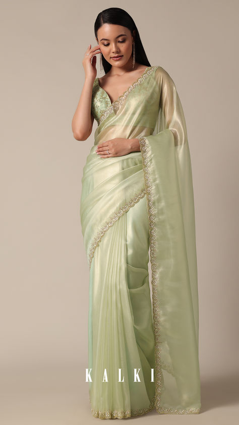 "Step into sophistication with this Graceful Green Tissue Saree. It is featuring meticulous bead and cutdana work on a scalloped border. The light green and glass tissue accents enhance the overall appeal, creating a perfect choice for your party wear collection. Meticulous detailing and the inclusion of unstitched blouse fabric ensure a customized fit.
" Mint Green Saree Look, Lux Green Saree Contrast Blouse, Light Green Saree Look, Green Tissue Saree, Pastel Green Saree, Pista Green Saree, Light Green Saree, Saree With Hijab, Golden Blouse Designs