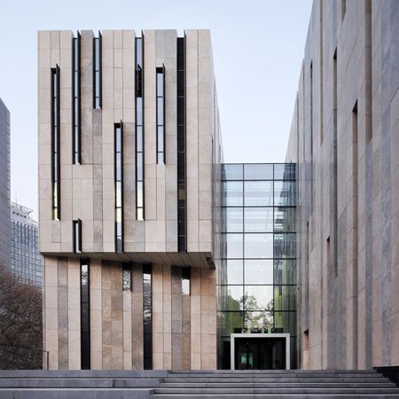 German studio KSP Jürgen Engel Architekten have completed an art museum in Nanjing, China, with a series of narrow rectangular slits across the facade. Called Jiangsu Provincial Art Museum, the building features two u-shaped structures which are joined by a central glass-roofed atrium. The  travertine stone façade is up broken by tall windows, which are زها حديد, Fasad Design, Metal Facade, Concrete Facade, Stone Facade, Zaha Hadid Architects, Museum Architecture, Glass Facades, Nanjing