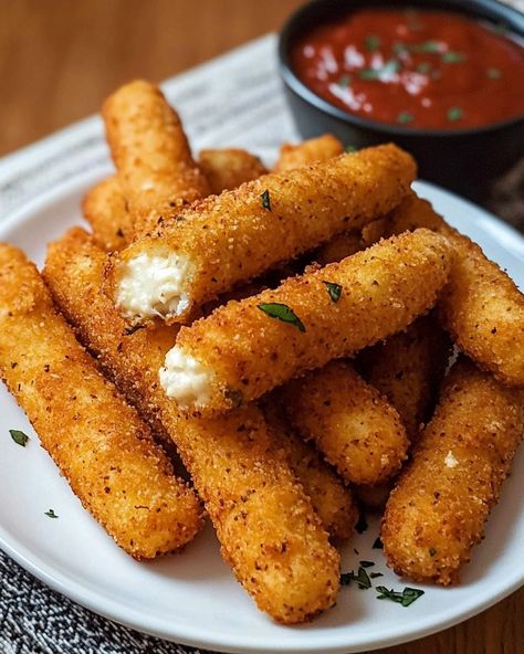 Irresistible Mozzarella Cheese Sticks 🧀🍅 Ingredients: 12 mozzarella string cheese sticks, cut in half 1/2 cup all-purpose flour 2 large eggs 2 tablespoons milk 1 1/2 cups Italian-style breadcrumbs 1 teaspoon garlic powder 1 teaspoon dried parsley 1/2 teaspoon salt 1/4 teaspoon black pepper Oil, for frying Marinara sauce, for dipping Instructions: Place the cut mozzarella sticks on a baking sheet lined with parchment paper. Freeze for at least 1 hour until solid. Prepare three bowls: one w... Homemade Mozzarella Sticks, Mozzarella Sticks Recipe, Mozzarella Cheese Sticks, Black Pepper Oil, Dried Parsley, Sweet Dishes Recipes, String Cheese, Mozzarella Sticks, Cheese Sticks