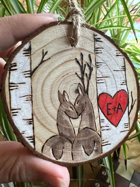 **This is a Made to Order item** Show someone you love them enough to carve your initials in a tree (slice)! This wooden ornament of a heart and initials carved into a birch tree can fit up to 2 characters inside the heart (2 letters and a plus sign). A buck and doe stand beside the birch trees, nuzzling.  Birch trees have been admired for centuries for their ability to endure and grow. What better symbol for a relationship?  This ornament is first burned into the wood with a pyrography tool and Natural Christmas Tree Decorations Rustic, Couple Wood Burning Ideas, Wood Slice Bear, Wooden Slice Crafts, Diy Christmas Tree Ornaments Handmade, Pyrography Christmas Ornaments, Wooden Ornaments Painted, Large Wood Slice Crafts, Wood Burned Christmas Ornaments