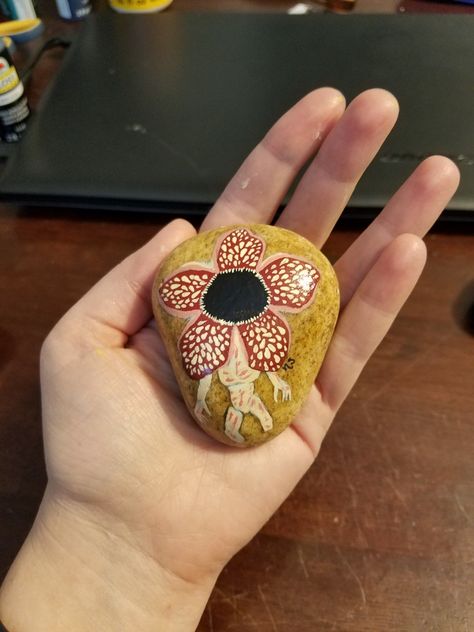 Stranger Things demogorgon painted rock Stranger Things Rock Painting, Rock Painting Ideas Stranger Things, Stranger Things Diy Gifts, Stranger Things Gift Ideas Diy, Stranger Things Painted Rocks, Skull Rock Stranger Things, Stranger Things Eggos, Movie Painted Rocks, Creepy Rock Painting