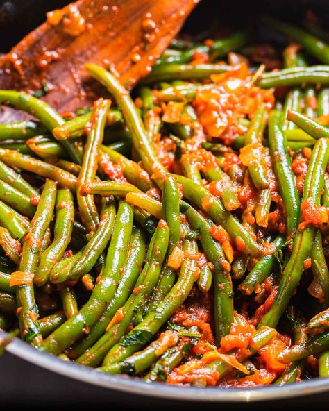 Fresh green beans are gently stewed in a tomato sauce that is full of garlic and onion flavor. Topping with fresh herbs, like basil and parsley, a drizzle of extra virgin olive oil, and plenty of grated Pecorino or parmesan brings this dish to the next level! #greenbeans #stringbeans #italiansides #summerrecipes #italianrecipes Green Beans In Tomato Sauce Recipe, Green Beans With Tomato Sauce, Italian Style Green Beans Recipe, Green Beans With Sauce, Green Beans With Tomatoes And Onion, Italian Green Beans Recipe, Green Beans In Tomato Sauce, Bean Ideas, Beans In Tomato Sauce