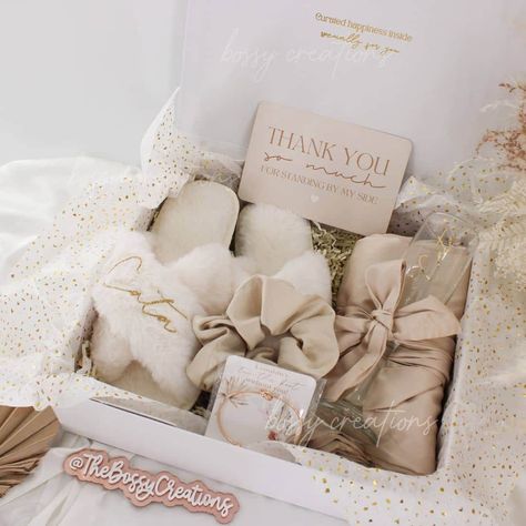 Step into a world of luxury with our Neutral / Taupe Fluffy Slippers Bridesmaid Gift Box. Designed for the modern bride who wants to spoil her bridal party, this exquisite gift box includes a sumptuous satin robe, a matching hair scrunchie, a personalized mimosa champagne glass, and a pair of white personalized fluffy slippers together with a minimal knot bracelet. Indulge your bridesmaids in pure comfort and style as they prepare for your special day. These handmade slippers are not only cozy a Bridesmaid Proposal Gifts Luxury, Bridesmaid Wedding Gifts From Bride, Bridesmaid Boxes Wedding Day, Wedding Day Bridesmaid Gifts From Bride, Bridal Party Day Of Gifts, Bridesmaid Morning Of Wedding Gift, Day Of Gifts For Bridesmaids, Thank You Bridesmaid Gifts, Bridesmaid Thank You Gift