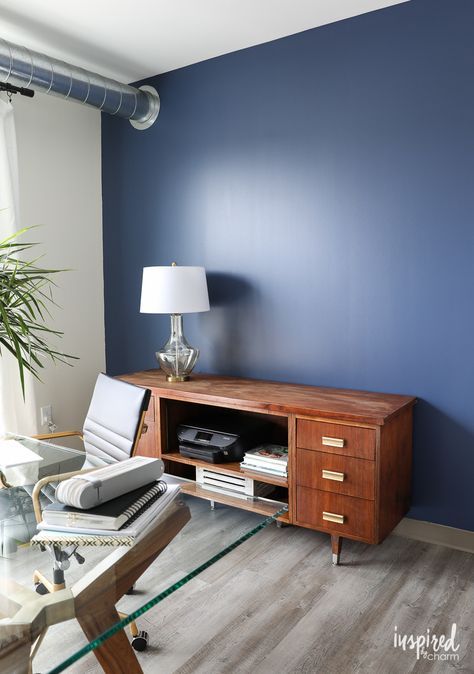 the navy blue accent wall is Sherwin Williams, Indigo Batik - Feature Wall Paint for the Home Office - Inspired by Charm Sherwin Williams Indigo, Blue Feature Wall Bedroom, Blue Accent Wall Living Room, Navy Blue Accent Wall, Feature Wall Paint, Home Office Blue, Blue Accent Wall, Blue Feature Wall, Office Feature Wall