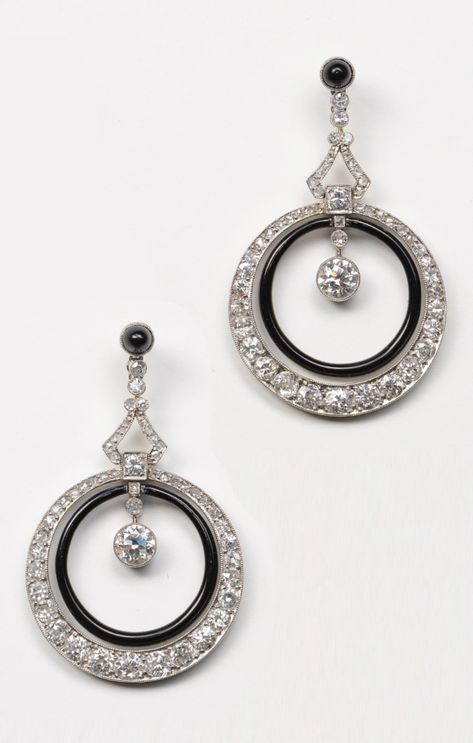 A pair of Art Deco platinum and diamond earrings, French, circa 1920. Set with old-cut diamonds, the top is a small cabochon-cut onyx below which are two hoops connected by a triangle: the inner hoop is decorated with black enamel and the outer hoop is set with old-cut diamonds, suspended inside the hoop is a larger old-cut diamond. Art Deco Vintage Jewelry, 1920 Jewelry, Vintage Jewelry 1920, Art Deco Jewelry 1920s, Art Deco Jewelry Rings, Style Année 20, Round Cut Diamond Earrings, Bijoux Art Deco, Art Deco Jewelry Vintage