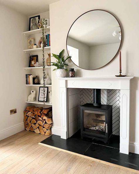 Renovated white living room with cast iron fireplace with mirror hanging over the mantel and built-in bookshelves Fireplace For Small Living Room, Living Rooms With Fireplace, Pink Bookshelves, Cast Iron Fireplace, Small Fireplace, Old Fireplace, Pink Living Room, White Living Room, Fireplace Remodel