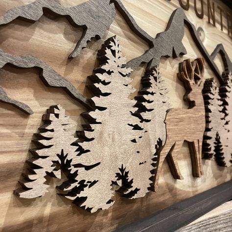 Perfect for a cabin, home or man cave... our "Gods Country" signage features incredible detail and accents brought to life by engraving, various wood thickness and carefully crafted stain finishes. Length: 11 7/8" Width: 23 5/8" Thickness: 1 3/16" Orientation: Horizontal Includes: 2 - Sawtooth Hangers Deer Scene, Cnc Machine Projects, Gods Country, Wood Burned Signs, Engraved Wood Signs, Cabin Home, Laser Cut Wood Crafts, Carved Signs, Farmhouse Crafts