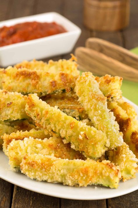 These oven-fried zucchini sticks are coated in a combination of panko crumbs and grated Parmesan cheese and baked in a hot oven until crispy and golden. Zucchini Sticks Recipes, Fried Zucchini Sticks, Oven Fried Zucchini, Zucchini Pommes, Parmesan Zucchini Chips, Fried Squash, Large Zucchini, Zucchini Sticks, Fried Zucchini