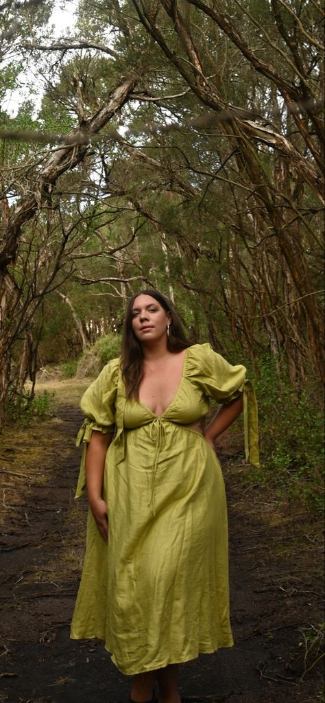 Green aesthetic dress in the Forrest with tall trees plus size model wears a pistachio green midi dress with a v neck and short sleeves that are puff with romantic ties on the arms. Cut outs on the waist and tie at the front. Plus size curvy fashion midi dress Plus Size Wedding Guest Dress Summer, Plus Size Cottagecore Fashion, Angelcore Fashion, Plus Size Wedding Guest Dress, Plus Size Summer Dress, Plus Size Midi Dress, Sustainable Fashion Designers, Curvy Wedding, Cottage Core Style