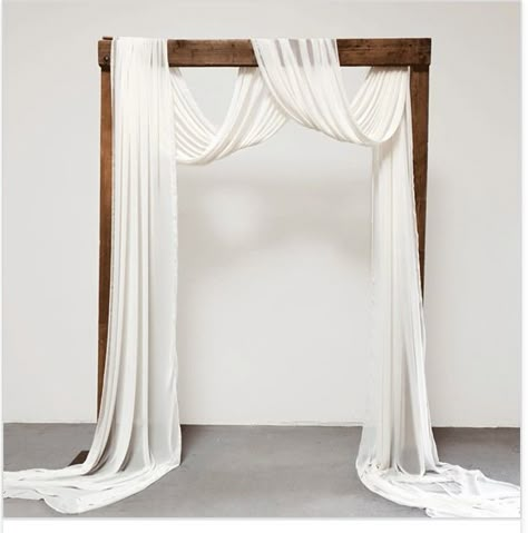 Minimal Wedding Arch Decor, Cloth Arch Wedding, Wedding Arbour With Fabric, Cheesecloth Draping Wedding, Fabric Arch Wedding, Wedding Arch Cloth Draping, Ceremony Arch Draping, Wooden Wedding Arch With Drape, Drapery Arch Wedding