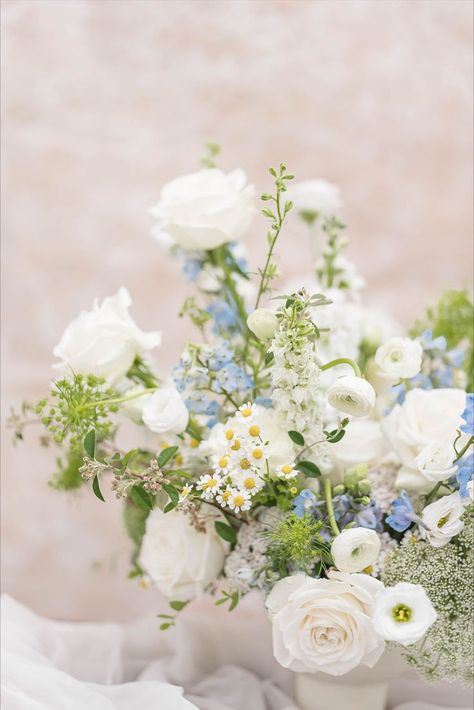 White wedding centerpiece with a hint of blue - adding a modern and romantic touch at any celabrtation #nofloralfoam #whitewedding #gardenstyle #microwedding White And Blue Flower Arrangements Simple Centerpieces, White Green Blue Yellow Wedding, Blue And White Baby Shower Flowers, Blue Wedding Flowers Table, Light Blue Floral Arrangements, Simple Blue Flower Centerpieces, Baby Blue Flower Arrangements, White Wildflowers Wedding, Long Floral Centerpiece Wedding