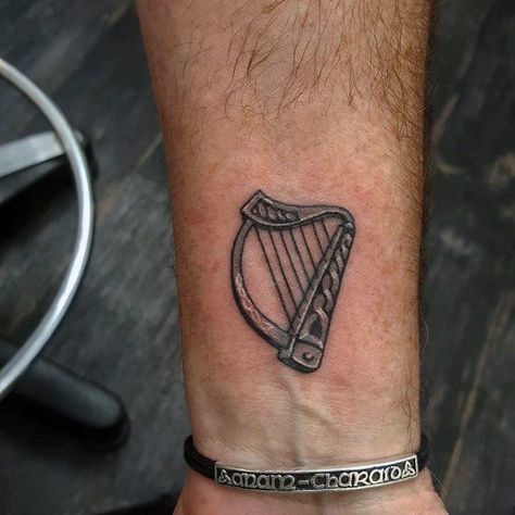 Mens Harp Tattoo Ideas Wrist Detailed Small Men’s Celtic Tattoos, Irish Harp Tattoo Men, Small Irish Tattoos For Men, American Traditional Harp Tattoo, Harp Tattoo Small, Celtic Harp Tattoo, Irish Tattoos Men, Harper Tattoo, Irish Harp Tattoo