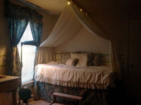 I decided to turn a twin bed into a raised daybed so I could store boxes underneath.  One thing led to another and I created my own "diy" bed canopy.  I love to repurpose  things so this cost me no money .... only some rummaging in my attic.  The canopy uses two wooden dowels as "curtain rods".  I put 2 sheer curtain panels on each.  I then put 4 screw hooks in the ceiling to hold the dowels.  The rest is a thumbtack here and there. Easy! Diy Canopy Twin Bed, Twin Bed Canopy Diy, Canopy Bed Against Wall, Diy Bed Drape, Canopy Over Daybed, Diy Canopy Curtains, Couch Canopy, Diy Bed Canopy Easy, Curtains Over Bed