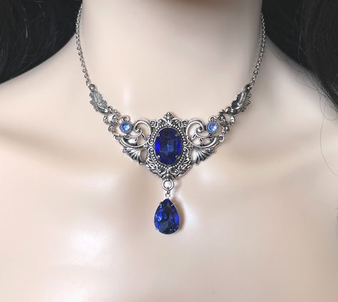 "This elegantly ornate necklace is made with antique silver tone centerpieces, featuring lavish baroque details. Its mesmerizing design is accented with dazzling sapphire blue glass crystals/jewels. Decorated portion is 4\" wide and 2 1/2\" tall in the very center. Necklace length is adjustable 14\"-17\" with soldered stainless steel cable chain, lobster clasp and extender. If you would like a different length, please send us a message. Earrings: These dainty and elegantly ornate earrings are ma Blue Crystal Jewelry, Dark Blue Necklace, Victorian Style Blue Necklaces For Formal Occasions, Royal Blue Necklace, Medieval Style Silver Necklaces For Fantasy Events, Luxury Blue Victorian Necklaces, Blue Medieval Necklace, Blue Victorian Pendant Necklace, 1800s Jewelry