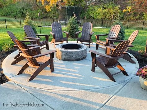 Fire Pit Ideas Off Patio, Backyard Round Fire Pit Ideas, Patio Ideas For Mobile Home, Adirondack Chairs Around Fire Pit, Fire Pit Near Pool Area, Fire Pit On Concrete Patio, Concrete Patio Fire Pit Ideas, Poolside Fire Pit Ideas, Concrete Patio Ideas With Fire Pit