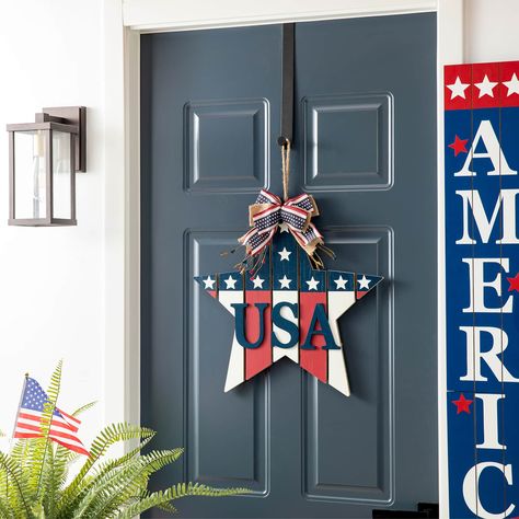 "Buy the Glitzhome® 19\" Patriotic American Wooden Star Door Hanger at Michaels. com. This handcrafted star door hanger features a slatted design, printed stars, dimensional USA letters and a twine bow on the top. This handcrafted star door hanger features a slatted design, printed stars, dimensional USA letters and a twine bow on the top. It's the ideal personalized door hanger and entryway décor to welcome guests during the holiday season. Details: Red, white and blue 19.25\" x 1.5\" x 18.25\" Star Door Hanger, Star Door, Twine Bow, Porch Pumpkins, Hanger Decor, Halloween Table Decorations, Wooden Pumpkins, Patriotic Stars, Wooden Stars