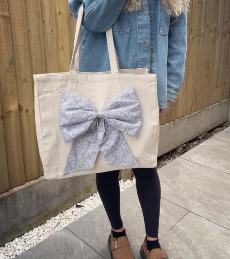 𝘓𝘪𝘣𝘦𝘳𝘵𝘺 𝘉𝘰𝘸 𝘛𝘰𝘵𝘦 𝘉𝘢𝘨𝘴 🌸🌼 Excited to finally share my Liberty Bow Tote Bags! The bows are handmade by me, attached to a canvas tote bag for a more glamorous, stylish look 😍 I made one of these for myself first and got so excited I just had to make more 😂 These will be available from tonight in my Etsy Shop. Currently 4 different fabrics but if they prove popular I may make more varieties. What do you think? Let me know in the comments! And as always, link to my shop in my bio 💐🌻🪻 #liberty #l... Bow Bag, Fabric Bows, Handmade Bows, Liberty Of London, Liberty Fabric, Bag Dress, Canvas Tote Bag, Different Fabrics, Gifts For Girls