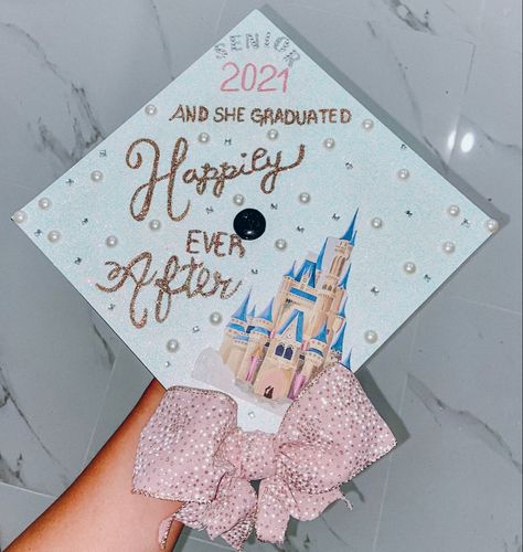 A DIY graduation cap color light blue or baby blue inspired by Disney magic kingdom Cinderella castle with a pink ribbon bow and gold sparkly and glittery letters saying and she graduated happily ever after with some pearls and rhinestones all around the graduation cap for senior year 2021 Disney Grad Caps, Disney Graduation Cap, Disney Graduation, Pin Pics, White Caps, Graduation Cap Designs, Disney Magic Kingdom, Cap Decorations, Graduation Cap Decoration