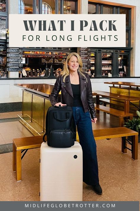 A woman stands with a beige roller bag and black backpack. She is wearing a brown moto jacket and jeans. Best Long Haul Flight Outfit, Best Outfit For Long Flight, What To Take On A Long Flight, Carry On Essentials Long Flights, Long Flight Outfit Summer, Long Haul Flight Outfit Comfy, In Flight Essentials, Carry On Bag Essentials Long Flights, What To Wear On Long Haul Flights